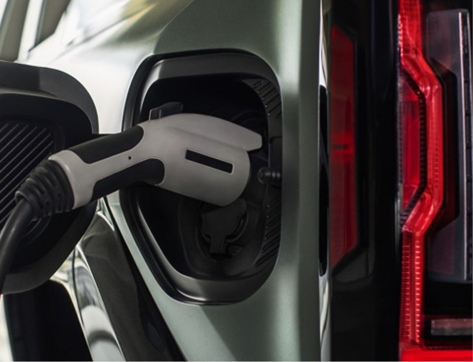 Close up of charging port with charger plugged in on a GMC Hummer EV SUV - Gustman Buick GMC in Kaukauna WI