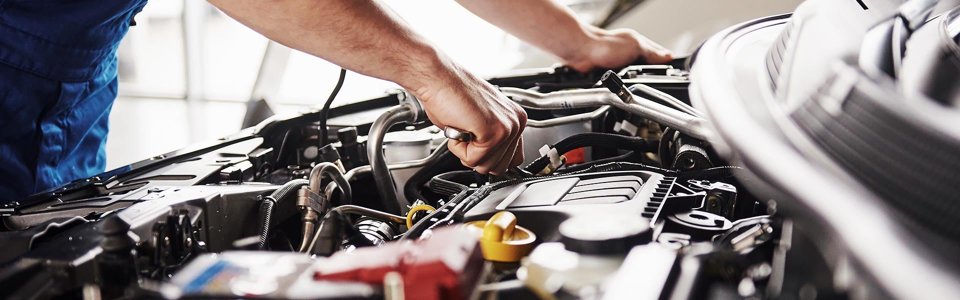 A certified maintenance specialist works on GMC SUV engine