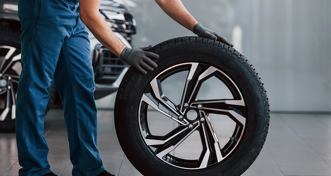 Image of a technician holding a tire on the floor